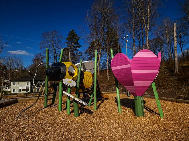 artistic wooden playground with a big bee and a flower