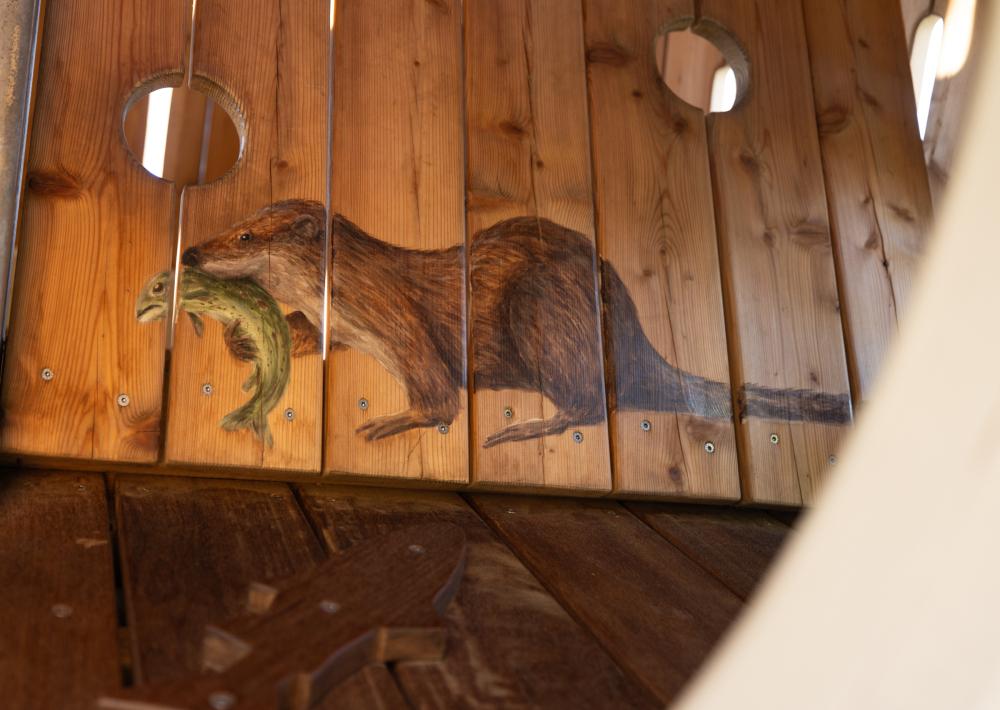 Painting of otter on the inside of wooden playground structure