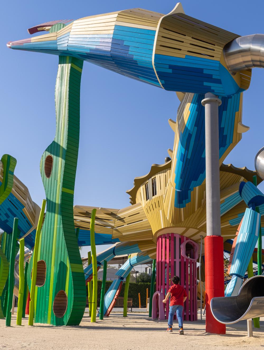 Boy running towards huge crab playground feature