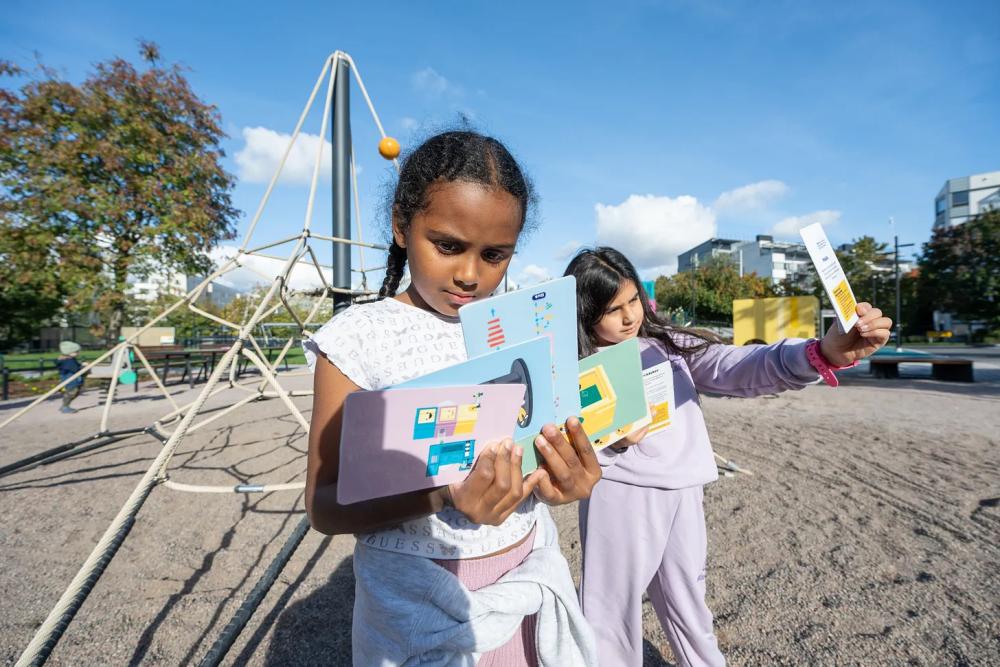 Children using educational activity cards at playground