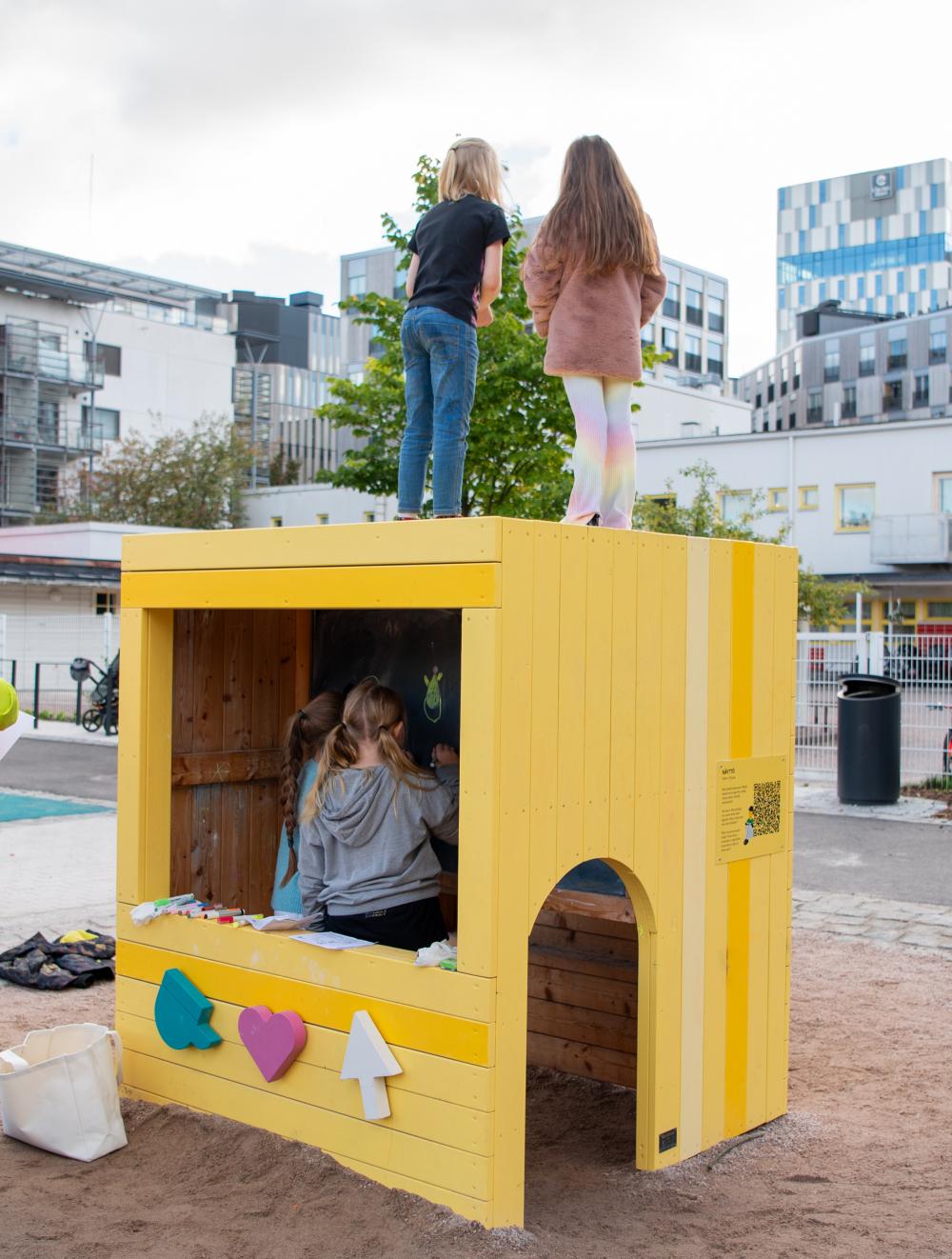 Kids playing in and on top of wooden play house