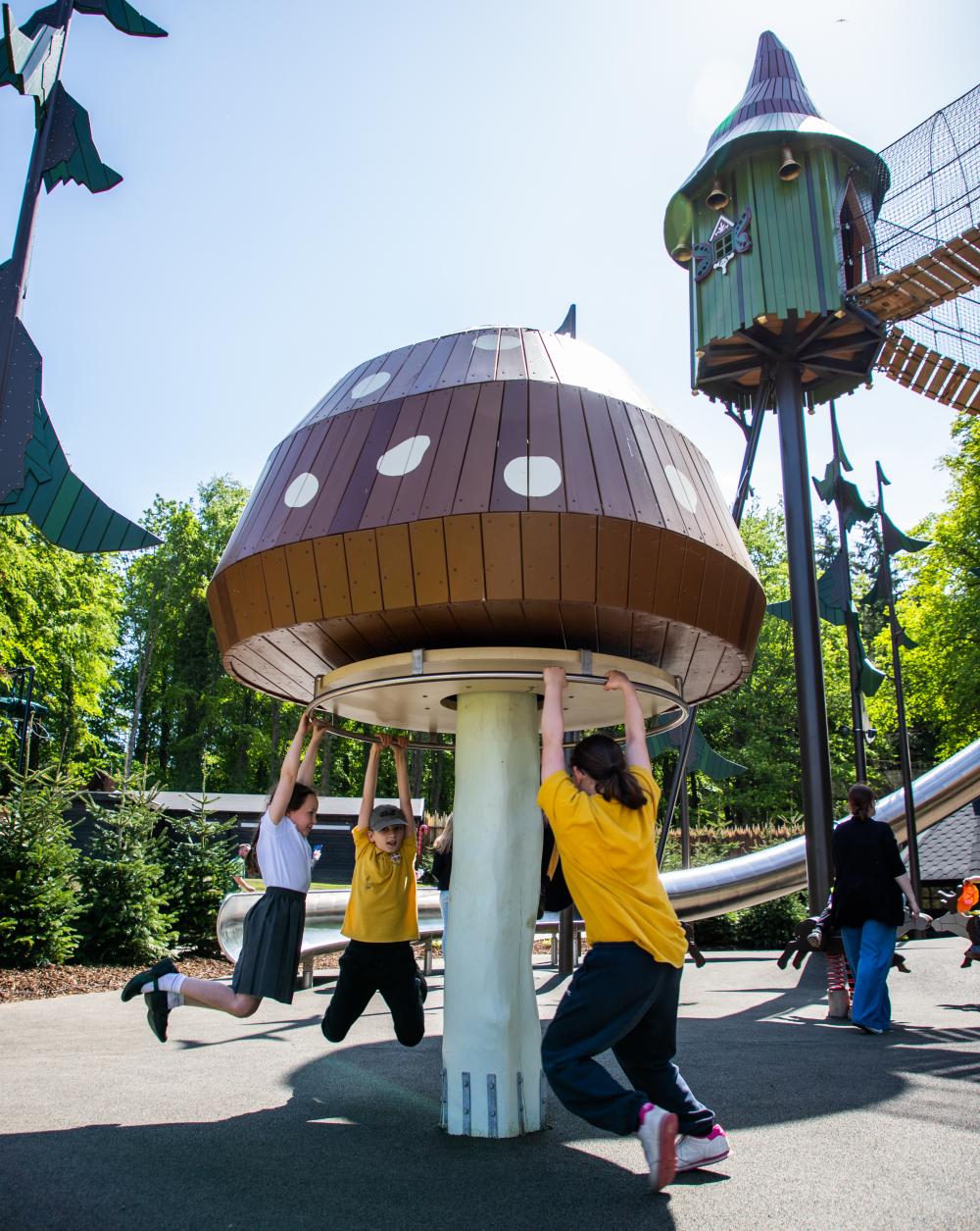 Big mushroom carrousel with children spinning round together 