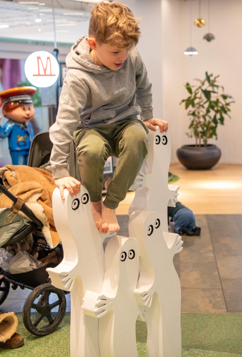 Boy climbing on Moomin characters