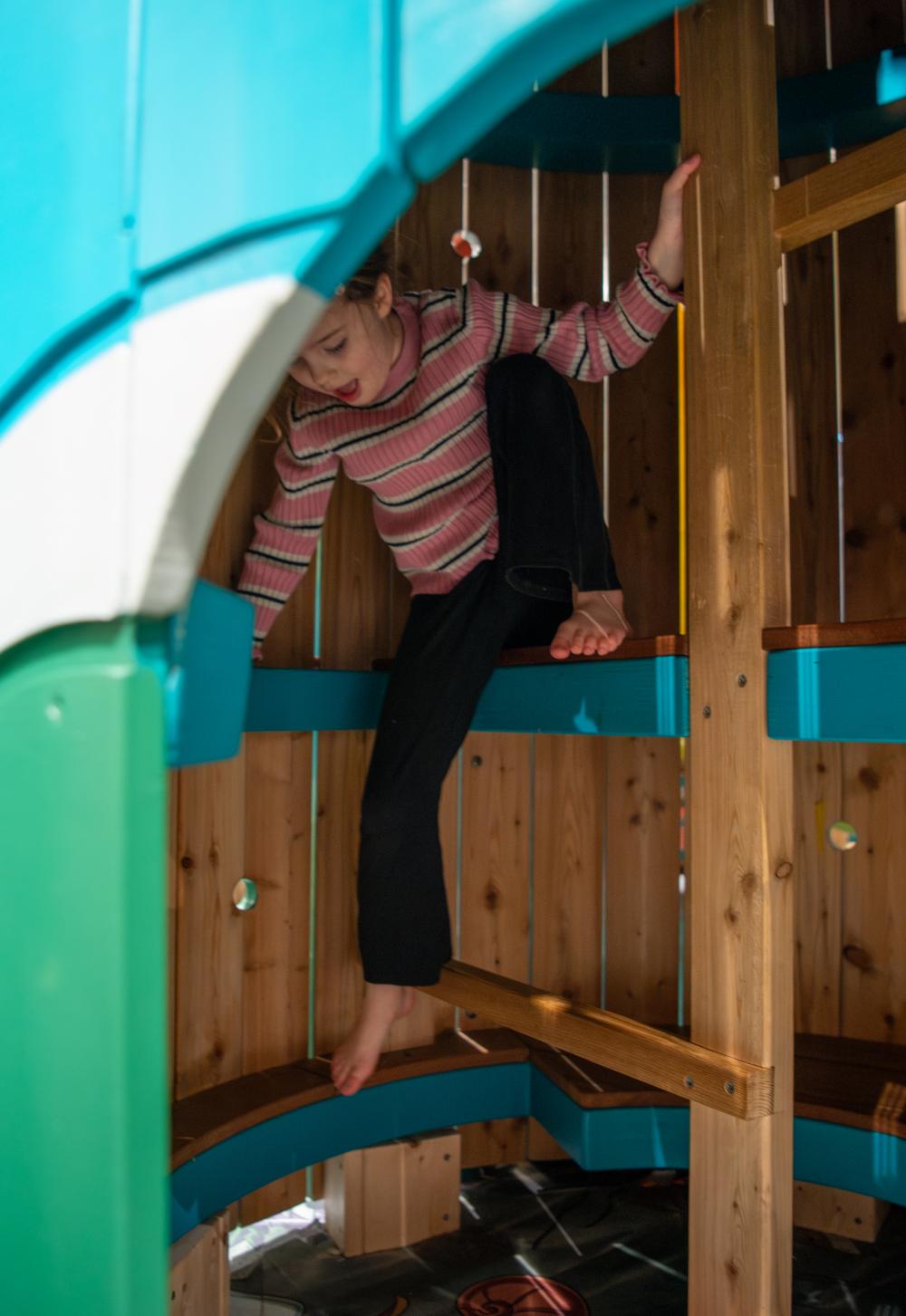 Girl climbing in playground tower