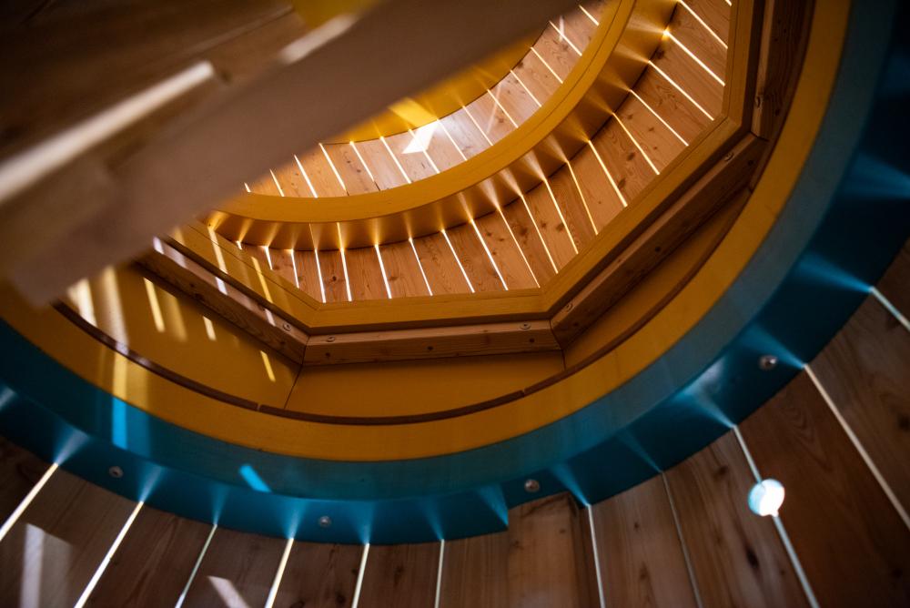 Inside playground construction with light streaming in between the wooden boads