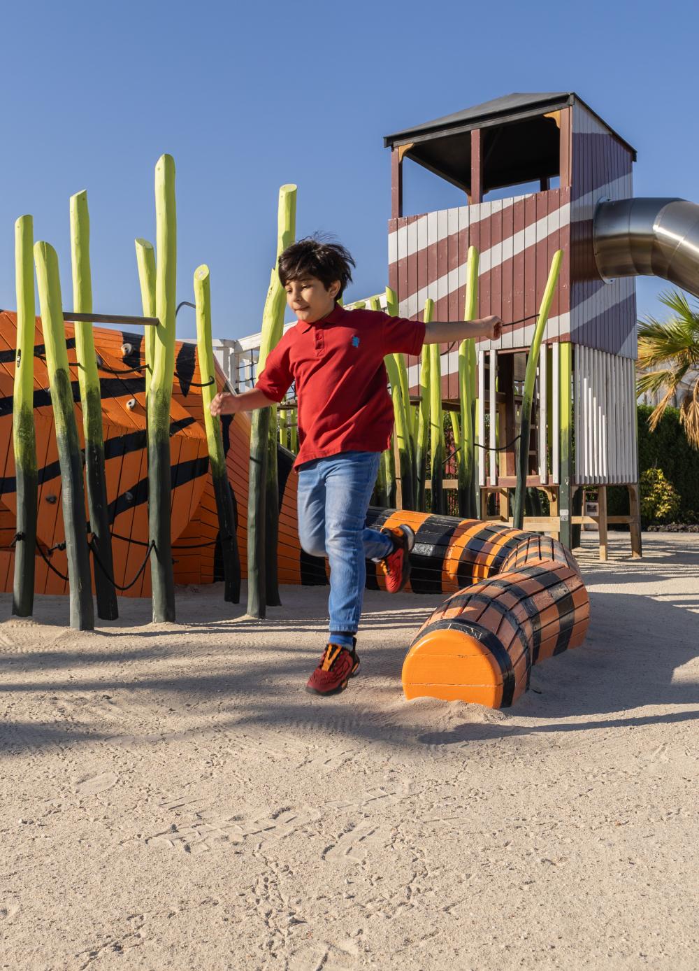 Boy jumping from playground tiger structure