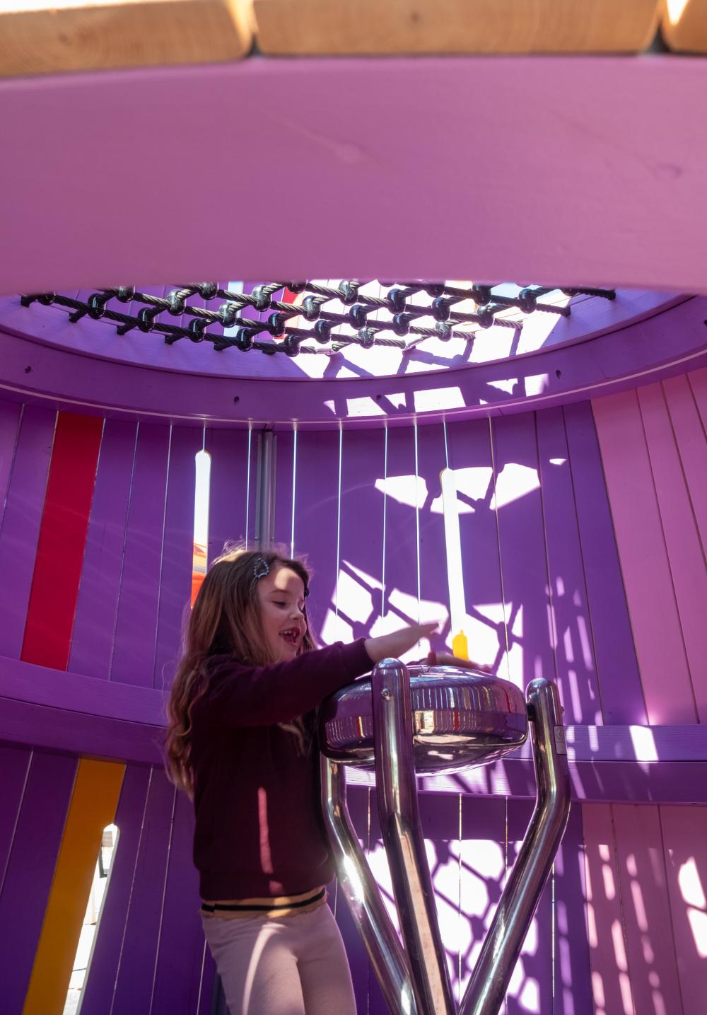 Girl playing on steel musical drum at playground