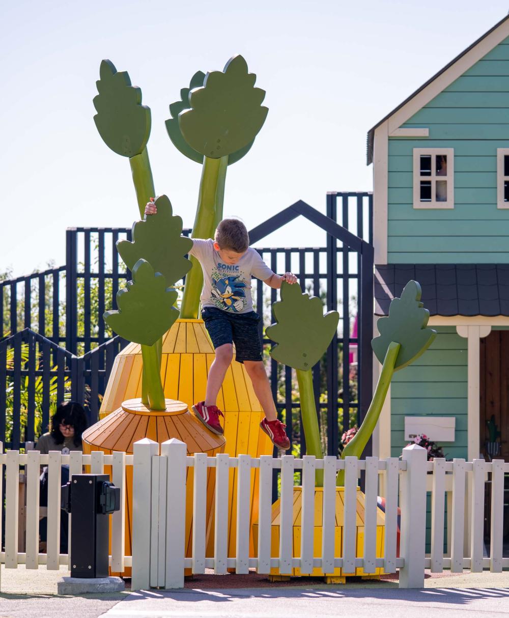 Boy climbing on wooden playground carrots