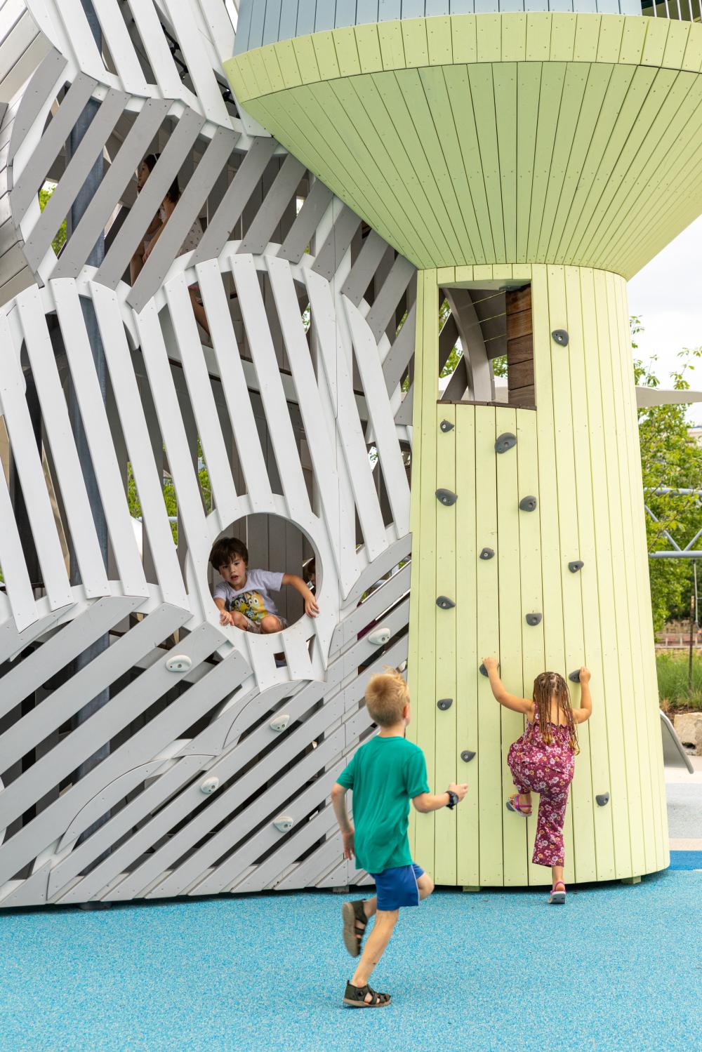 Kids playing in playground tower at aviation-themed playground