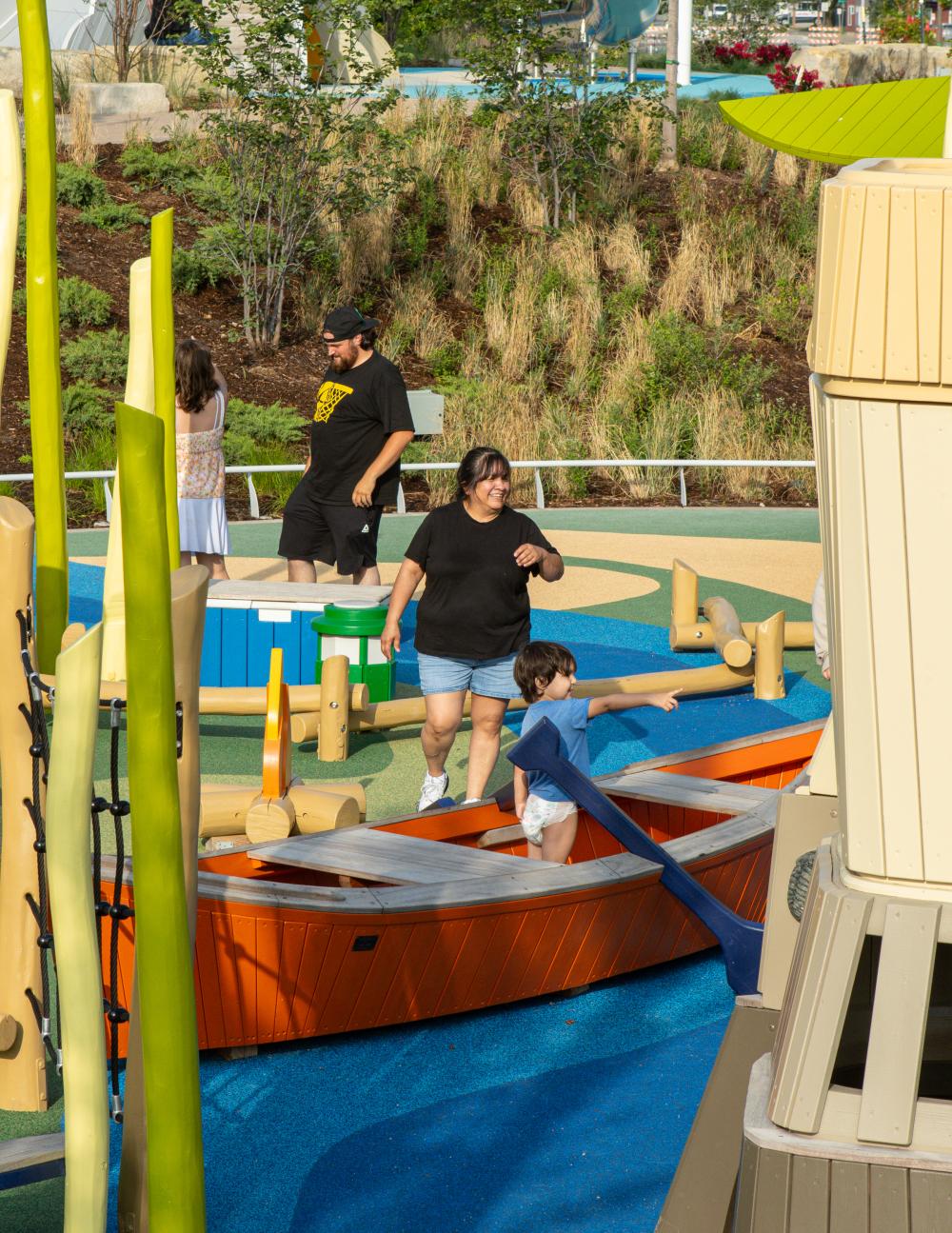people having fun at themed playground with wooden canoe